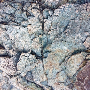 A bluish-green boulder with triangular texture.