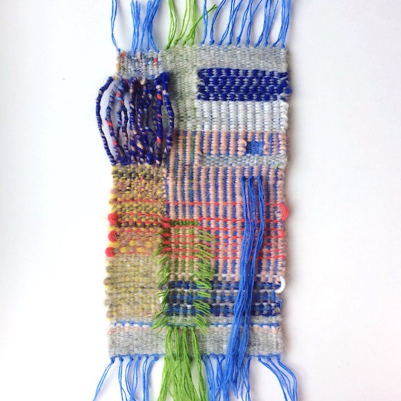 Rectangular weaving, featuring varigation, stripes, plaid, fringe, geometric shapes and twisted fibers. In gray, blues, red, green, yellow, browns and white.