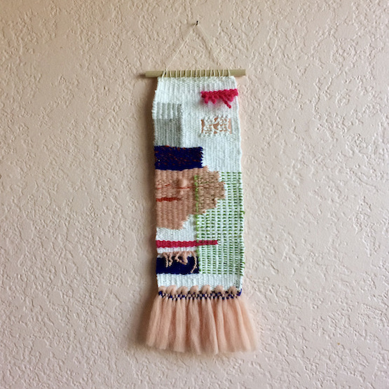 Rectangular weaving with organic and geometric shapes, spanish lace, twisted roving fibers, and fringe resembling a tutu. In blush, hot pink, cobalt, green, gray and white.